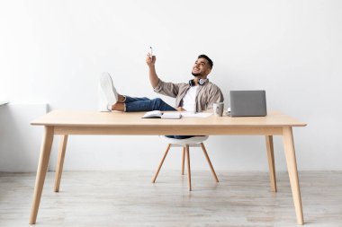 Genç bir Arap, evdeki klimayı açıyor.