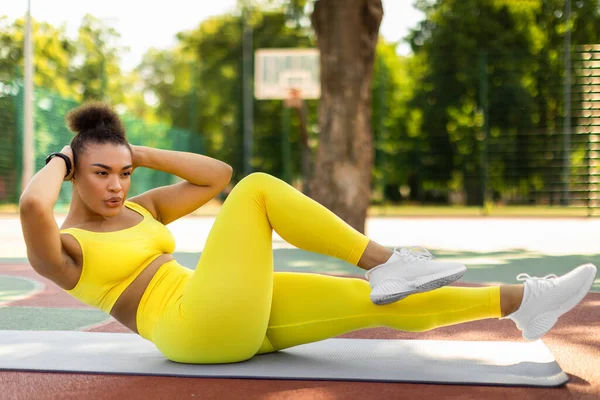 Jovem mulher negra fazendo exercícios abdominais, rachaduras laterais — Fotografia de Stock