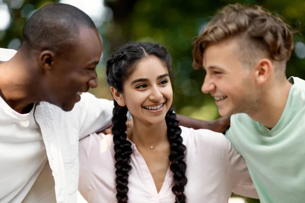 Retrato de estudantes universitários multirraciais alegres andando ao ar livre após passar no exame, abraçando e sinceramente rindo, — Fotografia de Stock