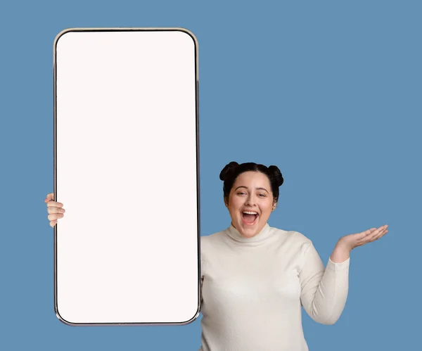 Veselá tlustá dáma s chytrým telefonem drží něco neviditelného — Stock fotografie