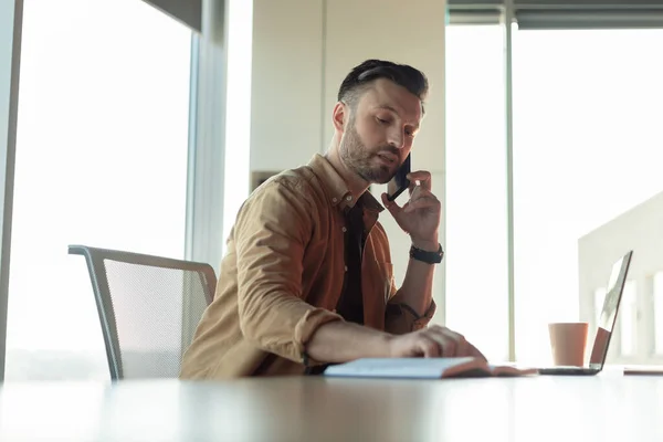 Affärsman talar på telefon med anteckningar Arbeta sitter på arbetsplatsen — Stockfoto