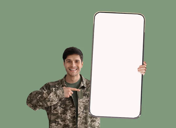 Военный, показывающий хороший смартфон с пустым экраном — стоковое фото
