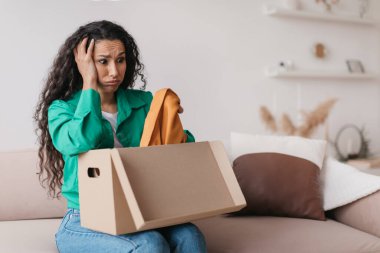 Hoşnutsuz Orta Doğulu Alışverişkolik Kadın Giysilerle Kutuları Açıyor