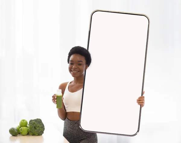 Atlético preto senhora com fresco mostrando smartphone, mockup — Fotografia de Stock