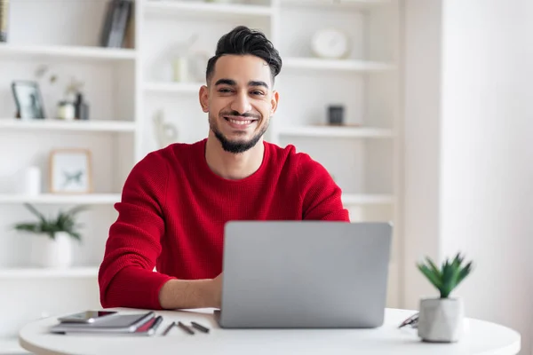 Retrato de sonriente guapo árabe masculino freelancer posando en el escritorio con computadora portátil — Foto de Stock