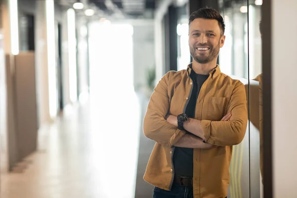 Feliz hombre de negocios posando parado en la puerta de la oficina moderna — Foto de Stock