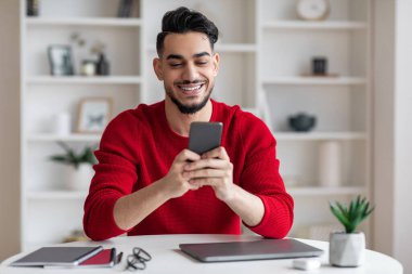 İçişleri Bakanlığı 'nda masasında otururken akıllı telefon kullanan Arap Erkek Serbest Çalışan