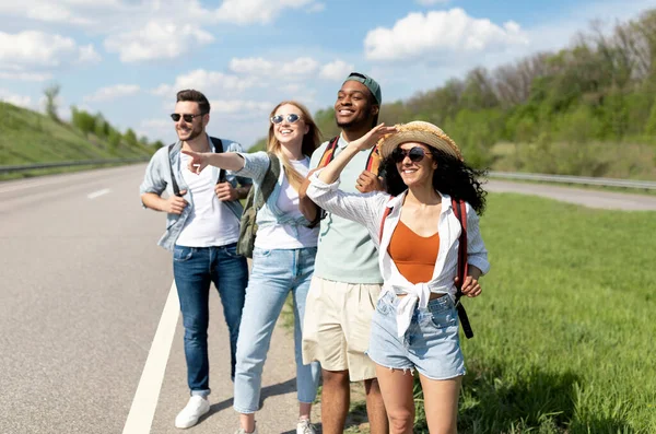 Grupo de amigos felizes em pé na beira da estrada, carona em férias de verão, indo para o campo, parando de carro — Fotografia de Stock