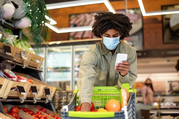 スーパーでマスクをして買い物をする黒人男性 — ストック写真