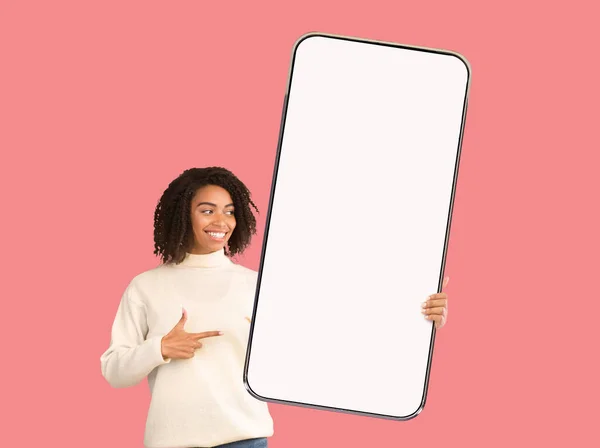 Mulher negra feliz segurando enorme smartphone com tela vazia — Fotografia de Stock