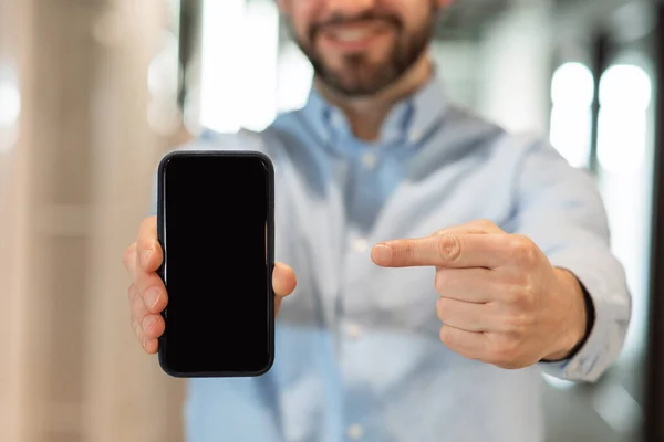 Бізнесмен вказує на чорний порожній екран смартфона — стокове фото
