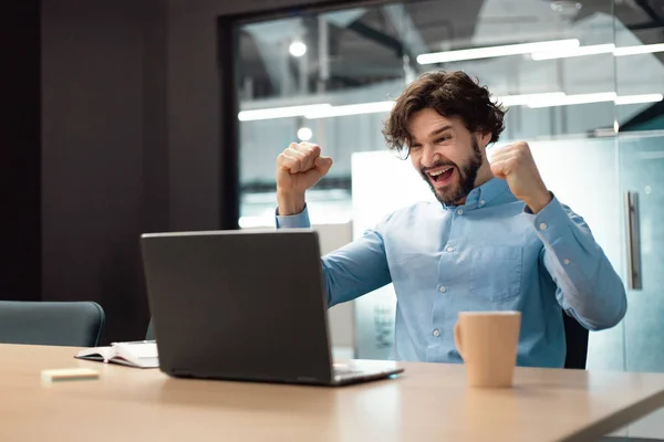 Emocionado hombre de negocios usando el ordenador portátil celebrando el éxito agitando puños gritando sí — Foto de Stock