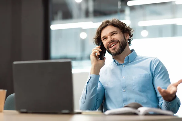 Leende affärsman som jobbar och pratar i mobiltelefon på kontoret — Stockfoto