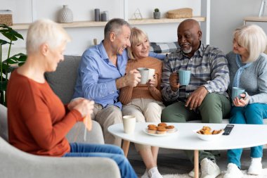 Olumlu çok ırklı yaşlılar huzurevinde birlikte vakit geçiriyorlar.