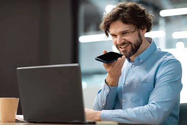 Sonriente hombre trabajando y hablando por teléfono en la oficina — Foto de Stock