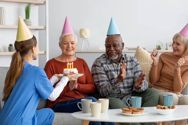 Šťastná starší žena slaví narozeniny v pečovatelském domě — Stock fotografie