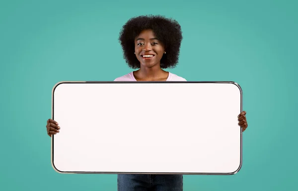 Alegre milenar preto senhora mostrando grande horizontal celular, mockup — Fotografia de Stock