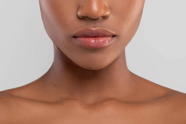 Gri arka planda izole edilmiş mükemmel bir teni ve dudakları olan üzgün, güzel, Afro-Amerikalı bir kadın. — Stok fotoğraf
