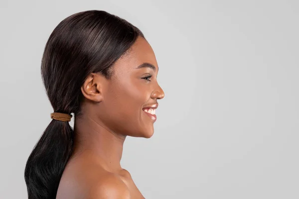 Alegre muito milenar senhora americana africana com pele perfeita e cabelo brilhante isolado em fundo cinza — Fotografia de Stock