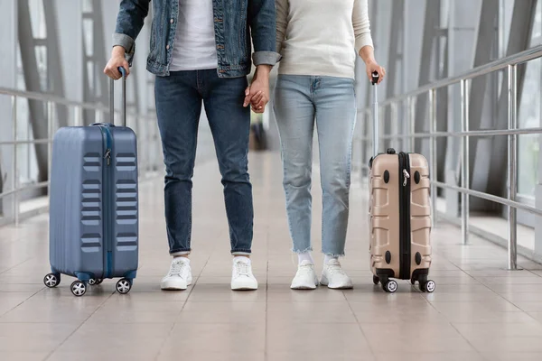 Pareja irreconocible viajando juntos, de pie con el equipaje en la terminal del aeropuerto — Foto de Stock