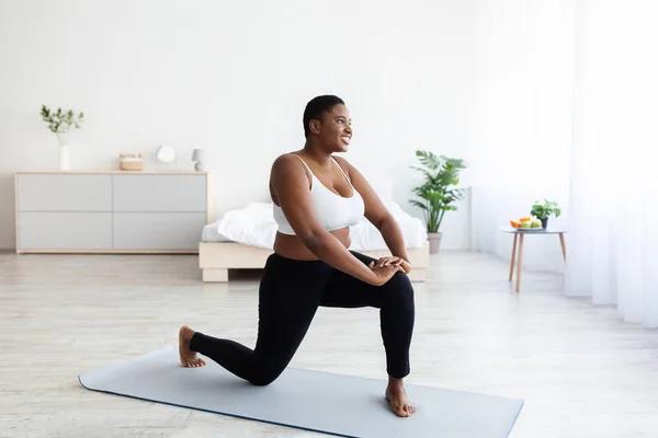 Ejercicios efectivos de peso corporal. Mujer negra joven con sobrepeso haciendo ejercicio doméstico, espacio para copiar —  Fotos de Stock
