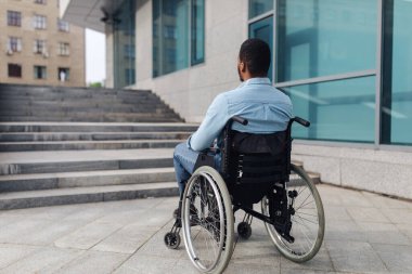 Tekerlekli sandalyedeki genç siyahi adamın merdivenlerin önünde rampasız durduğunu, binaya girmekte zorlandığını görüyorum.