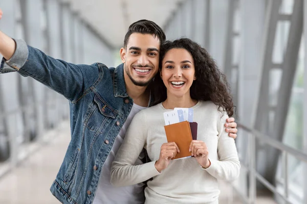 Mutlu Gezginler. Havalimanında selfie çeken, pasaportları olan neşeli genç bir Arap çift. — Stok fotoğraf