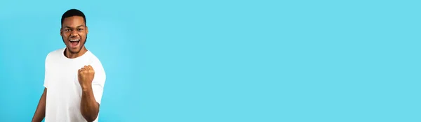 Büyük Galibiyet. Aşırı neşeli Siyah Adam Titreyen Yumruk, Mavi Arkaplan Üzerindeki Başarıyı Kutluyor — Stok fotoğraf