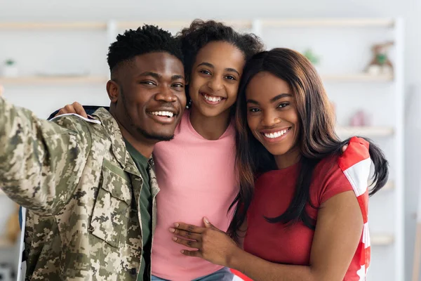 Family portrait of happy black kid, military husband and wife
