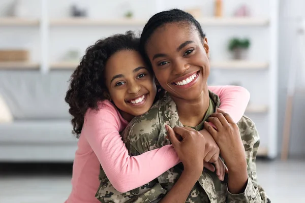 Πορτρέτο του χαρούμενου μαύρου κοριτσιού αγκαλιάζει τη μητέρα στρατιώτη της — Φωτογραφία Αρχείου