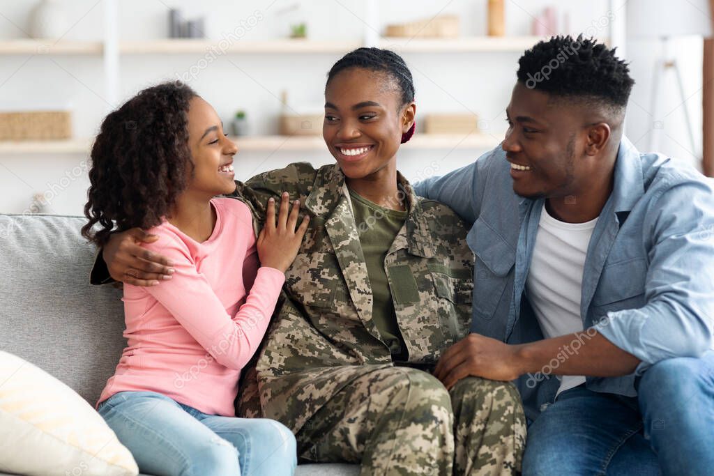 Loving african american family celebrating reunion with mother soldier