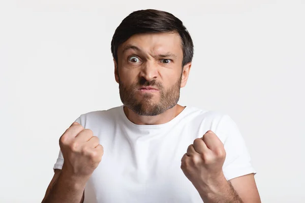 Hombre enojado apretando puños listo para luchar sobre fondo blanco —  Fotos de Stock