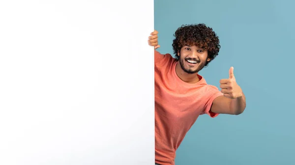 Mâncător pozitiv tip în picioare de bord de publicitate alb, gesturi — Fotografie, imagine de stoc