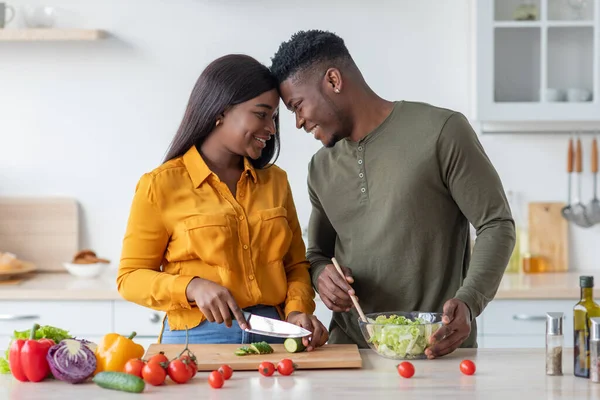 Cónyuges afroamericanos felices se unen en la cocina mientras preparan un almuerzo saludable juntos — Foto de Stock