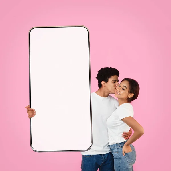 Amantes pretos mostrando telefone celular com tela em branco — Fotografia de Stock