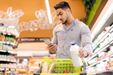 Orta Doğulu Adam Süpermarkette market alışverişi yapıyor.