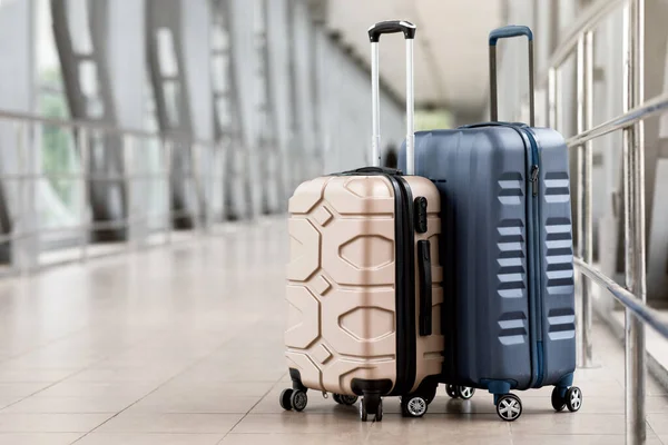 Reisemode. Großaufnahme von zwei Plastikkoffern, die auf dem leeren Flughafenkorridor stehen — Stockfoto