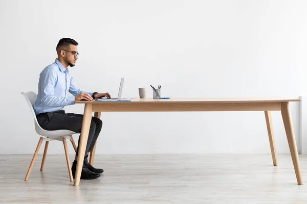 Άραβας που χρησιμοποιεί φορητό υπολογιστή κάθεται στο γραφείο στο γραφείο — Φωτογραφία Αρχείου