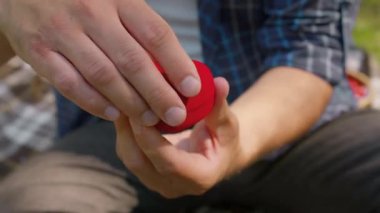 Beni mutlu edecek misin? Kafkasyalı adamın nişan yüzüğüyle mücevher kutusunu açtığı yakın çekim.