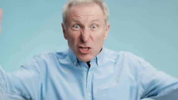 Výkyvy nálad. Zblízka portrét mrzutého staršího muže zlostně nadávající kameře, mluvení a obviňování rukou — Stock video