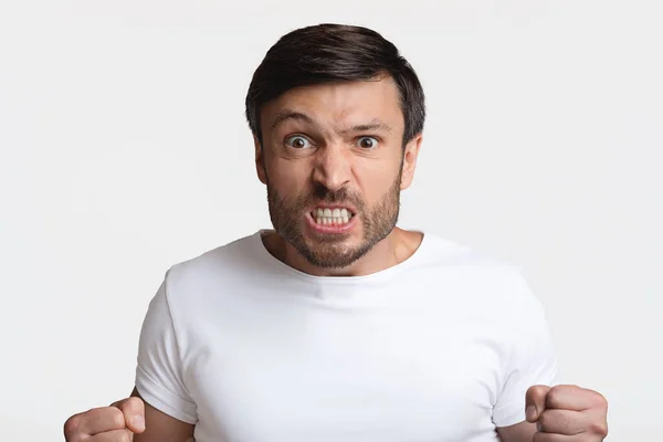 Furioso hombre apretando puños en rabia en blanco estudio fondo — Foto de Stock