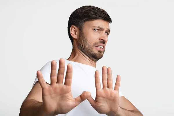 Hombre disgustado gestos dejar de evitar algo sobre fondo blanco —  Fotos de Stock