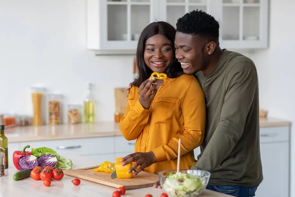 Jóvenes cónyuges negros alegres preparando comidas saludables juntos en la cocina — Foto de Stock