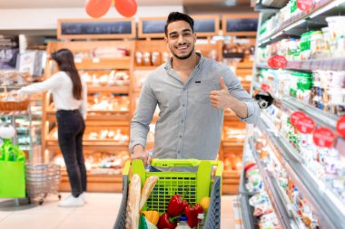 Neşeli Arap Erkek Alıcı Süpermarkette Baş Parmakla Alışveriş Yapıyor