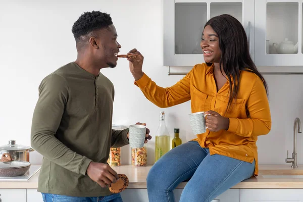 Jeune couple afro-américain s'amuser tout en mangeant des collations dans la cuisine — Photo