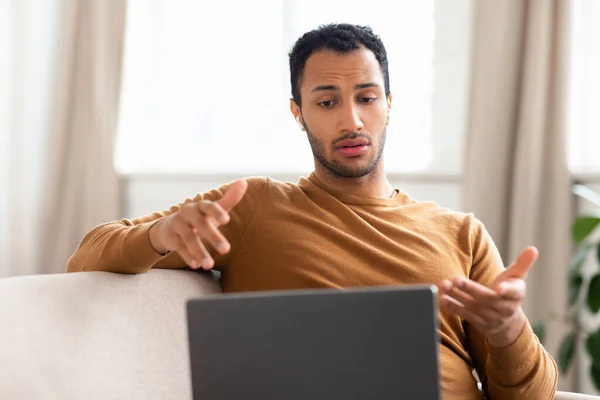 Arab férfi laptopot visel headset ül a kanapén — Stock Fotó