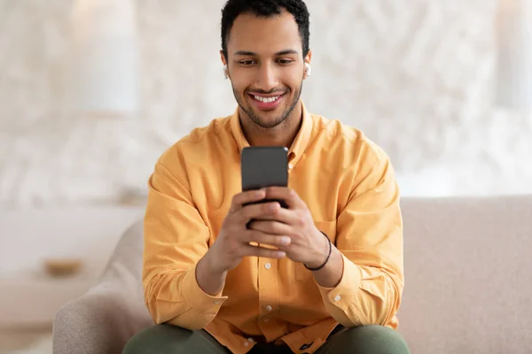 헤드폰을 쓰고 휴대폰을 사용하는 행복 한 아랍 남자 — 스톡 사진