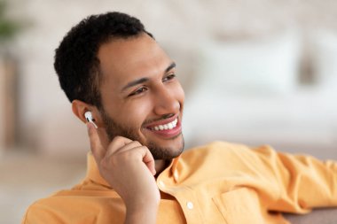 Sakin genç adam evde dinleniyor ve müzik dinliyor.