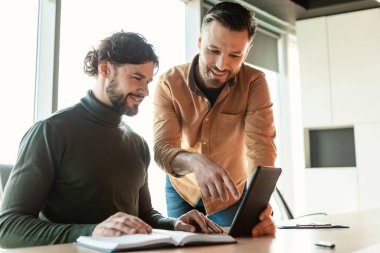 Modern ofiste tablet bilgisayar kullanan neşeli erkek arkadaşlar, boşluğu kopyalayın
