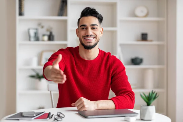 Allegro amichevole attraente giovane uomo d'affari arabo con la barba in vestiti rossi dà mano e saluta sul posto di lavoro — Foto Stock